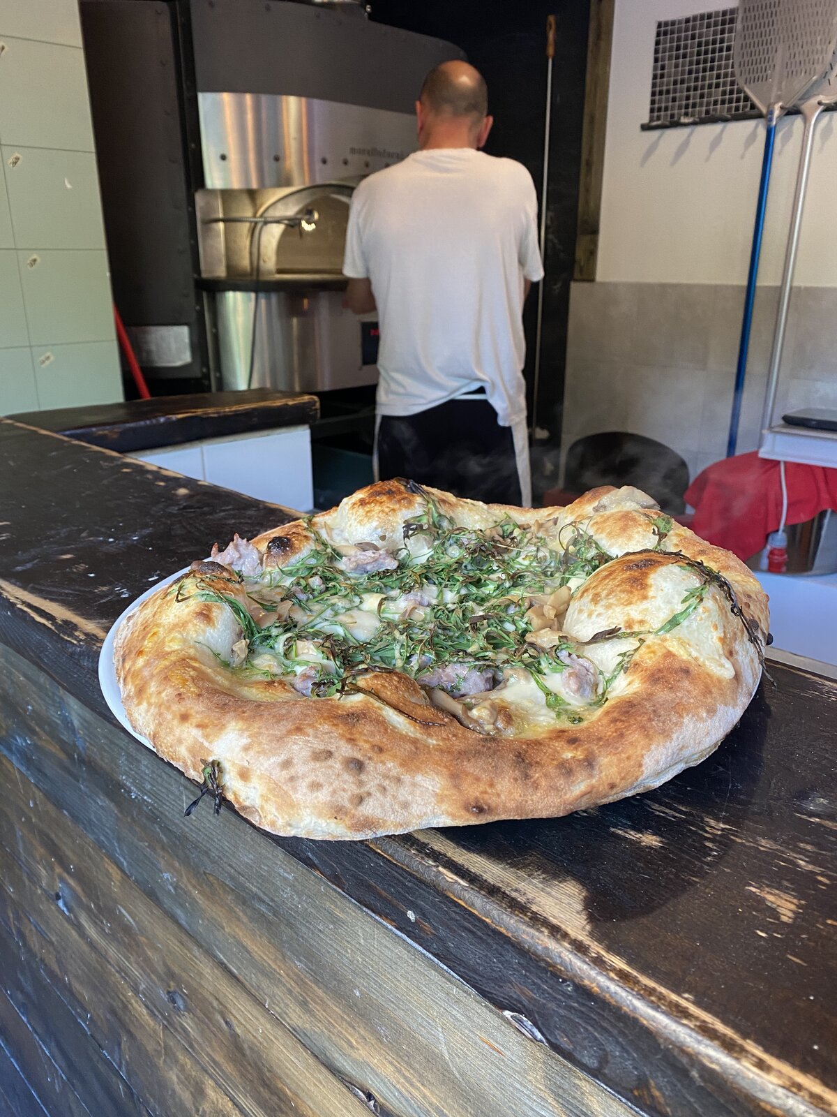 Pizza in cottura nel forno a legna di Rosso 17